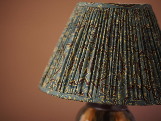 Textured lampshade with intricate patterns on a brown background